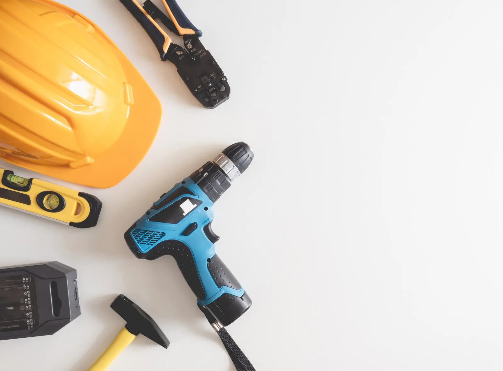 Hard hat, drill, level and hand tools ready for a home repair