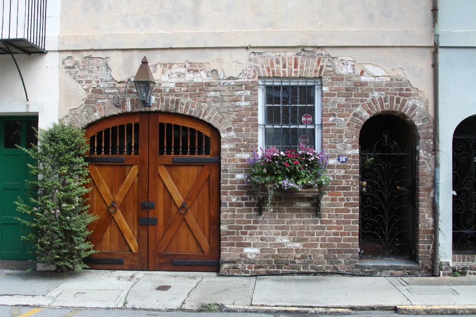 Brick building with a window box and arched wooden doors
