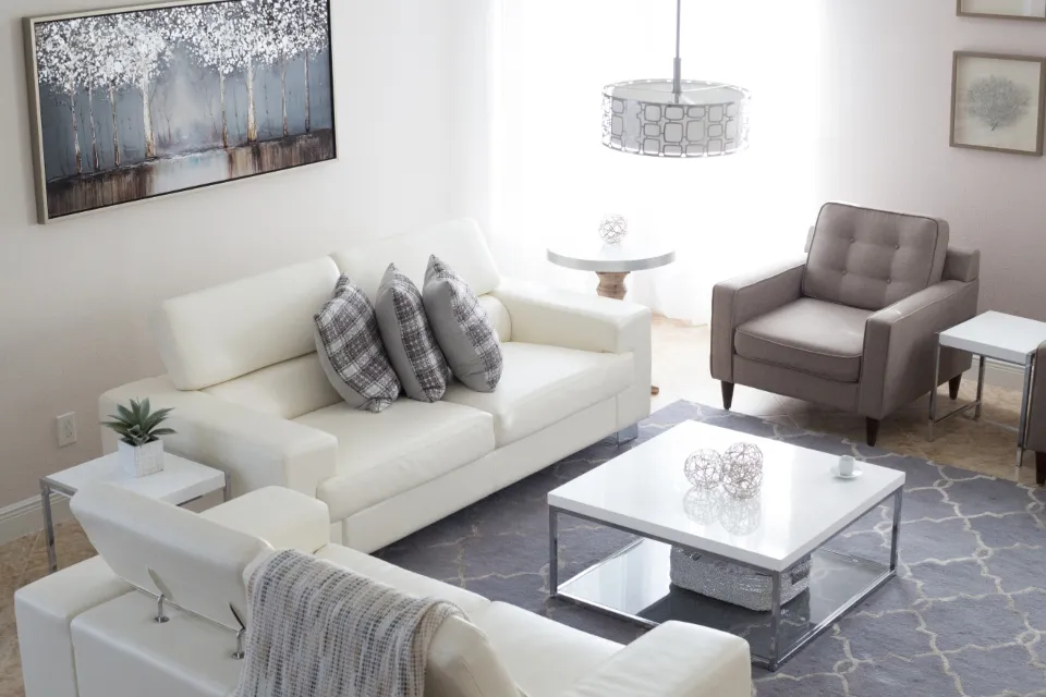 Bright, modern living room with white sofas and large windows