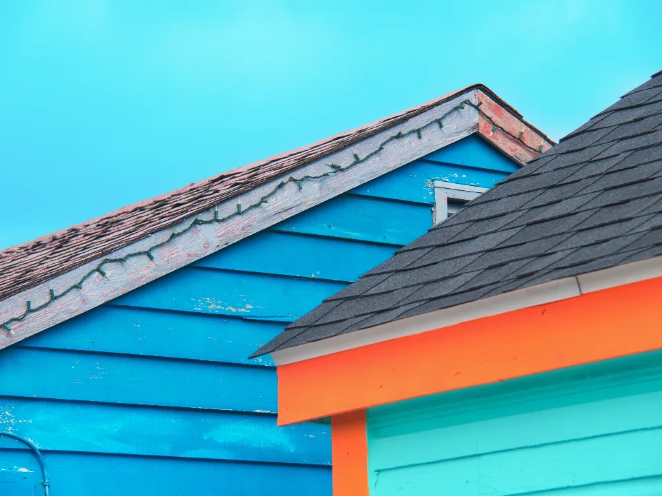 Blue and orange painted house siding and roof edge
