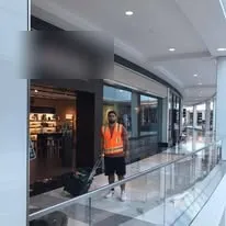 Crew member cleaning floors in a shopping mall corridor