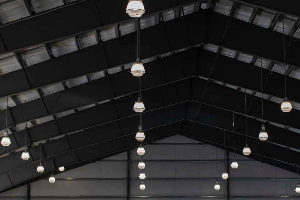 Exposed dark ceiling with lights in an unfinished space