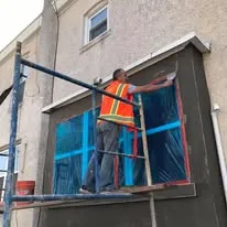Crew member on scaffolding installing an exterior wall section