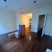 Newly finished room with hardwood floors and ceiling lights