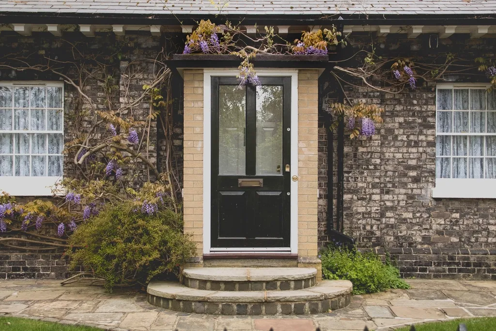 Dark front door with transom window on a brick house