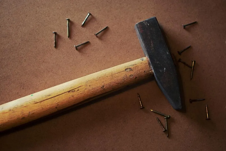 Hammer and nails on a brown surface