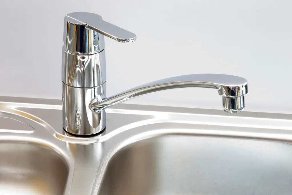 Chrome kitchen faucet over a stainless steel sink