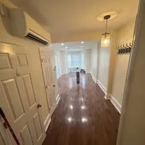 Renovated hallway with new hardwood floors, white doors and fresh paint