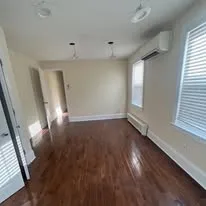 Renovated room with dark hardwood floors and fresh white walls