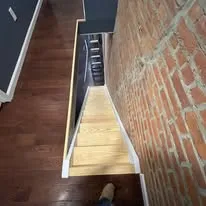 New staircase beside a restored brick wall, seen from above