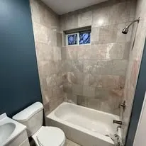 Renovated bathroom with a tiled tub surround and new fixtures
